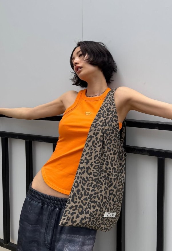 Nana en débardeur orange et pantalon large